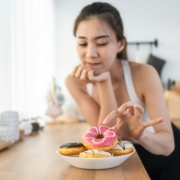 Asian beautiful young girl hungry and want to eat donut in kitchen