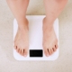 Person standing on white digital bathroom scale