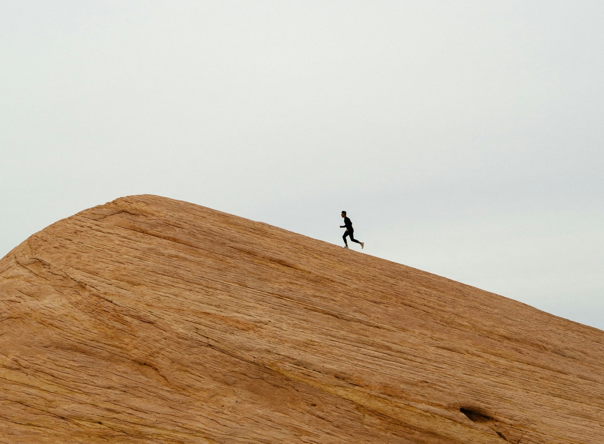 Person running on top of hill during daytime