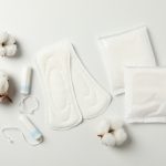 Sanitary pads, tampons and cotton on white background, top view
