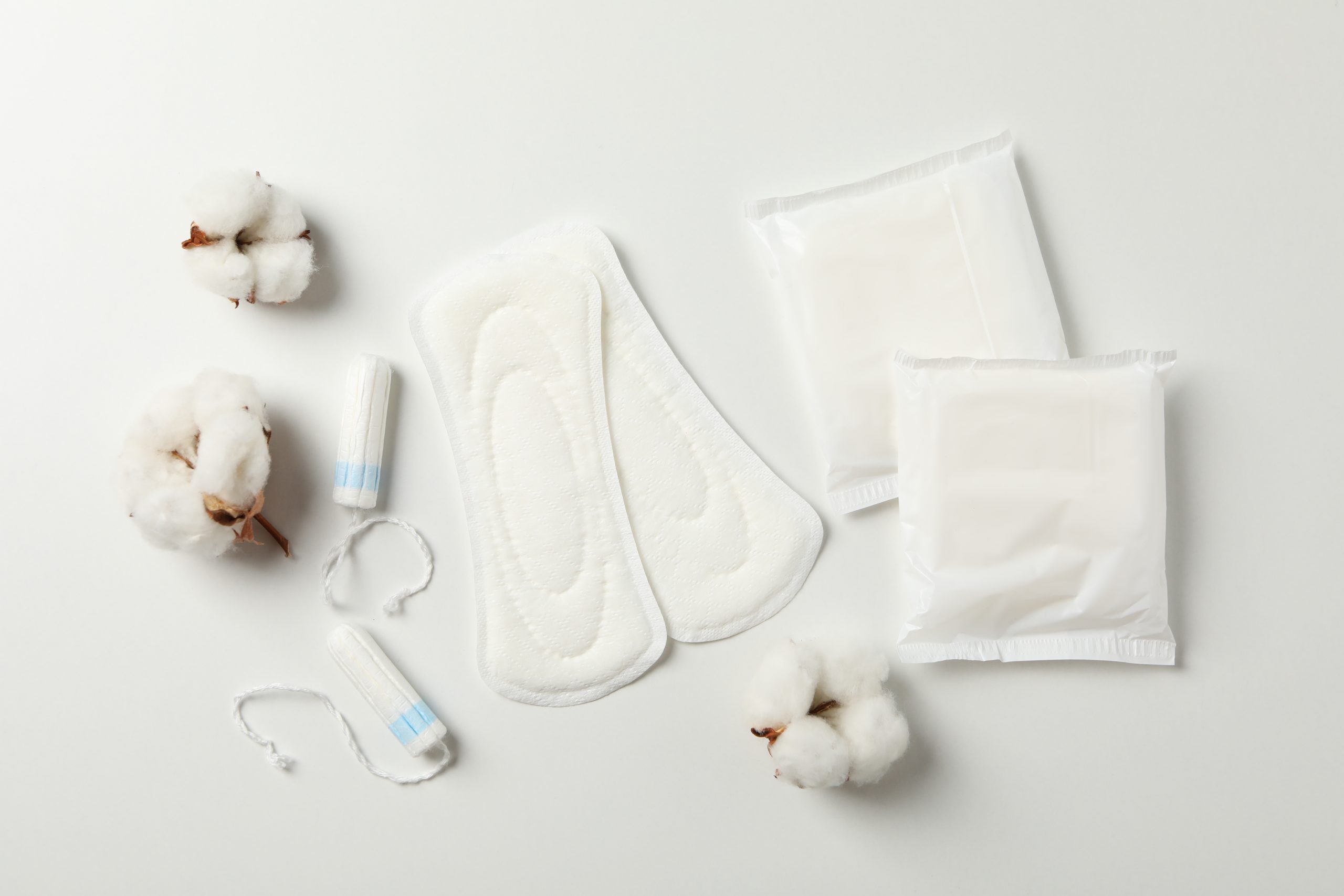 Sanitary pads, tampons and cotton on white background, top view